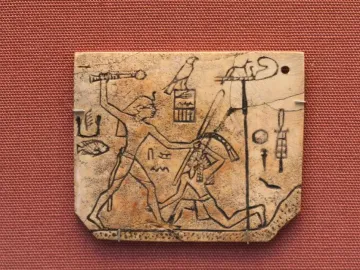MacGregor plaque showing a carved ivory tablet with a figure raising a mace over a kneeling figure, surrounded by hieroglyphs and symbols.