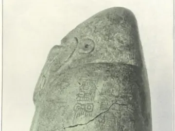 Right side of the Tuxtla Statuette showing a carved bird-like head and inscribed stone surface with a diagonal crack.