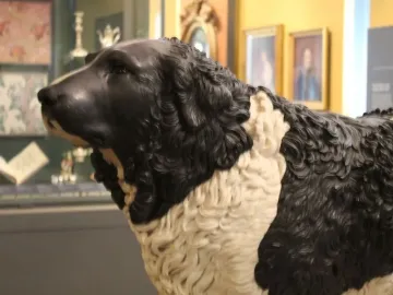 Close-up of the Bashaw dog sculpture with a textured black-and-white surface and raised head turned left.