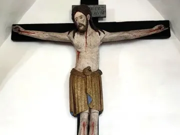 Enghausen Cross with a carved wooden crucifix of Jesus, showing a golden-brown loincloth and a plaque above the head.