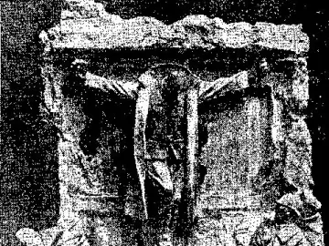 Canada\'s Golgotha sculpture showing a soldier fixed to a stone wall, with several uniformed figures looking up below him.