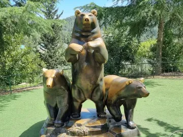 Group of Bears sculpture with a tall bear flanked by two smaller bears on a stepped base.