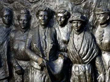 Bronze relief of six women on the Kate Sheppard National Memorial, with the central figure holding a rolled document.