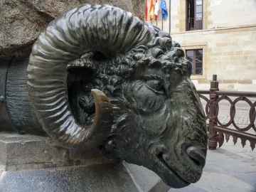 Close-up of the Monument to Viriato showing a dark metallic ram head with spiraled horns on a stone base.