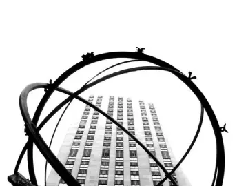 Atlas statue supporting a large armillary sphere with a tall building behind it.