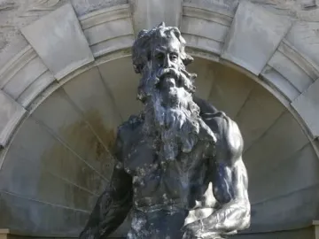 Court of Neptune Fountain sculpture of a bearded Neptune seated on rocks before an ornate stone alcove