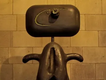 Joan Miró’s Mujer, an abstract dark metal sculpture with a rounded head-like form and an oval opening in the lower body.