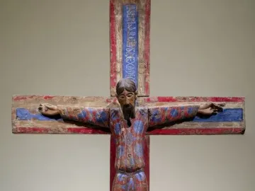 Batlló Majesty wooden crucifix showing Christ in a patterned red and blue tunic with outstretched arms.
