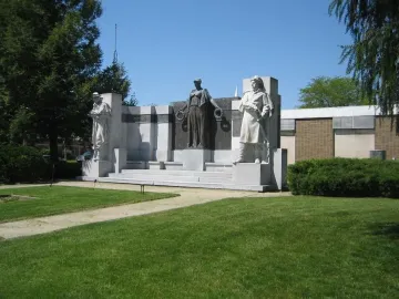 The Soldiers\' Monument, a stone and bronze memorial with two standing figures and a central bronze figure holding wreaths.