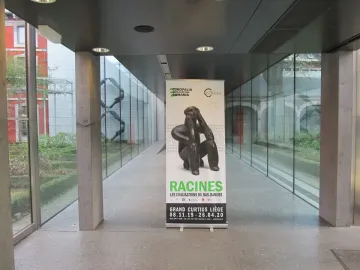 Banner showing The Thinker of Cernavodă in a contemplative seated pose inside a modern hallway.