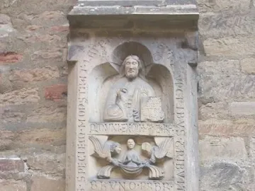 Tomb of Bruno the Priest stone relief with carved figures, angels, and inscriptions on a wall