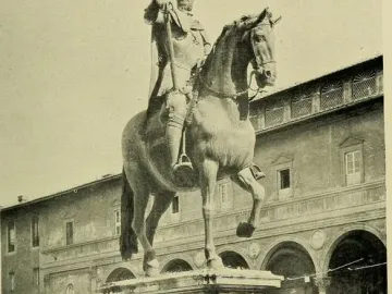 Ferdinando I de\' Medici equestrian statue on a stone pedestal in a public square with a historic building behind it.