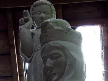 Our Lady of the Isles stone statue of a crowned woman in a hooded cloak with a child figure behind her