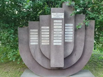 The Pit memorial with textured stone slabs and small plaques set in a grassy area.
