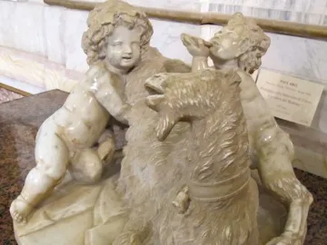 The Goat Amalthea marble sculpture with a shaggy goat lying down and two cherubic figures beside it.