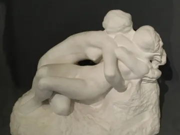 Rodin\'s Metamorphoses sculpture showing two intertwined nude figures on a textured base.