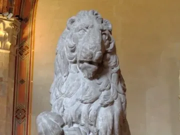 Marzocco, a seated stone lion with its paw on a shield decorated with a fleur-de-lis.