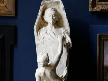 La Gloire sculpture showing a nude female figure pulling boards away from a coffin-shaped structure, revealing a male bust inside.