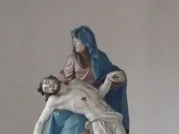 Nenningen Pietà sculpture showing Mary in blue and pink robes holding the lifeless body of Christ across her lap
