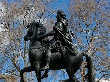 William III equestrian statue on a stone pedestal in St James\'s Square, with bare branches and buildings behind it.