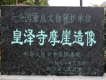 Stone monument at Huangze Monastery Rock Sculptures with bright teal Chinese characters carved into the surface