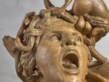 Screaming Medusa detail from Perseus and the Gorgon, with a contorted face, mouth agape, eyes looking upward, and snakes in the hair.