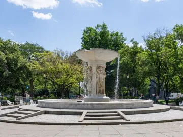 Dupont Circle Fountain with sculpted figures supporting the upper basin in a tree-lined plaza