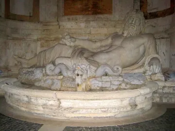Marforio, a reclining stone male figure with water flowing from a beast-head spout into a basin.