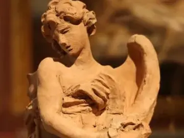 Terracotta sculpture of Angel with the Crown of Thorns, shown with a draped body, downward gaze, and a thorny crown held near the chest.
