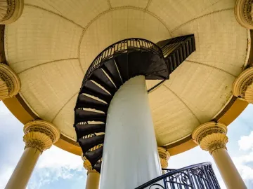 Spiral staircase inside the Hermann Heights Monument leading up to a patterned domed ceiling.