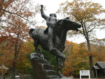 Israel Putnam Equestrian Statue showing a rider on horseback with a raised fist, framed by autumn trees.