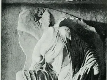Relief sculpture of Nike untieing her sandal, showing a draped female figure bent forward with her head partly obscured.