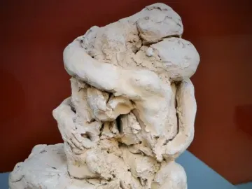 Sakuntala sculpture showing two intertwined figures in a rough terracotta embrace.