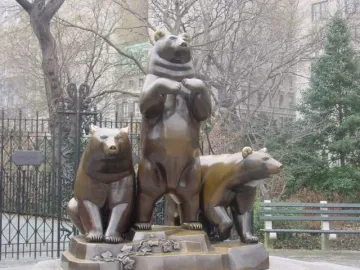 Group of Bears sculpture with three bear figures on a decorative base in a park.