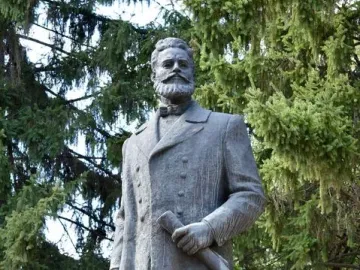 Bronze monument to Hristo Botev showing a bearded man in a long coat holding a rolled document.