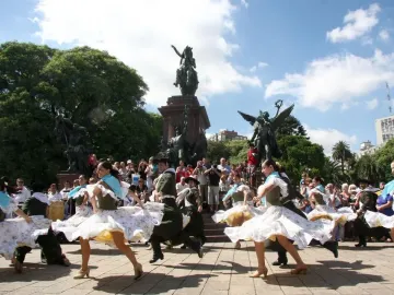 José de San Martín equestrian statue above dancers in traditional dress performing in a park