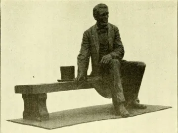 Bronze Seated Lincoln sculpture of Abraham Lincoln seated on a long bench with a top hat beside him.