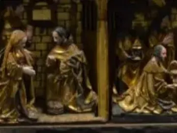 Lower register of the Fisenne Altarpiece showing gilded carved scenes with several figures gathered around an infant or basin.