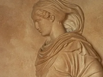 Gradiva relief showing a female figure in profile with flowing drapery and her head tilted downward.