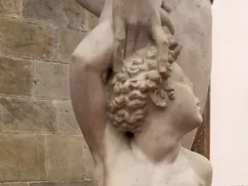 Marble sculpture of Apollo and Hyacinth showing a standing nude male figure and a kneeling figure beside him.