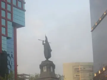 Cuauhtémoc Monument on a carved stone pedestal with a tall figure holding a staff or spear.