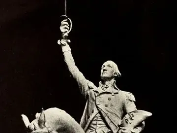 Monochrome statue of George Washington on a rearing horse, holding a raised sword and a hat.