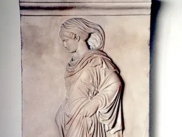 Gradiva relief showing a female figure in profile walking with one foot raised and draped in flowing garments.