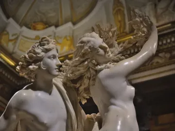 Close-up of Bernini’s Apollo and Daphne marble sculpture showing Apollo facing Daphne as her hair and arm transform into leaves and branches.
