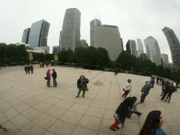 Cloud Gate reflects Chicago skyscrapers, trees, and people in the plaza.