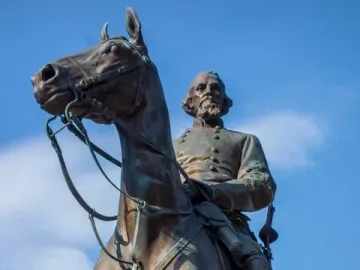 Nathan Bedford Forrest Monument, a bronze equestrian statue of a bearded man in military uniform against a blue sky.