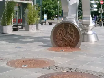 Footprints of the S-Printing Horse sculpture with circular lit plates set into the pavement.