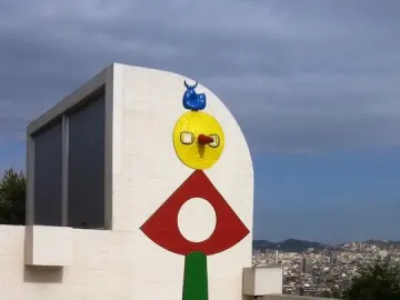 The Caress of a Bird, a tall abstract sculpture with stacked green, red, yellow, and blue forms.