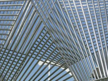 Éole sculpture with gleaming metallic bars fanning out against a blue sky.