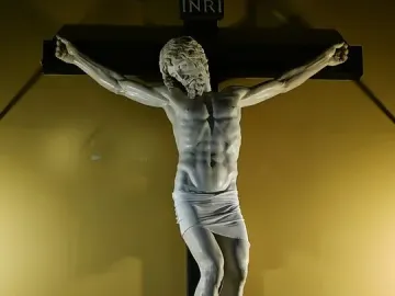 Benvenuto Cellini crucifix showing a white marble Christ figure on a dark wooden cross with INRI at the top.